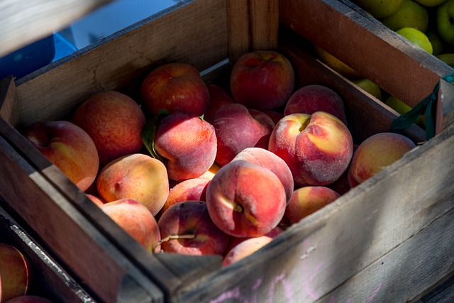 A wooden crate full of peaches